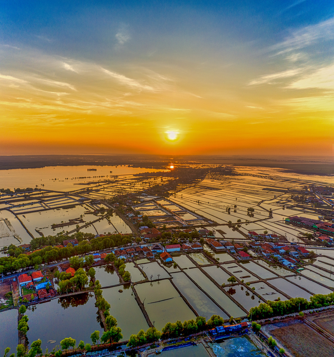 Fish farm against sea under shiny sun in twilight